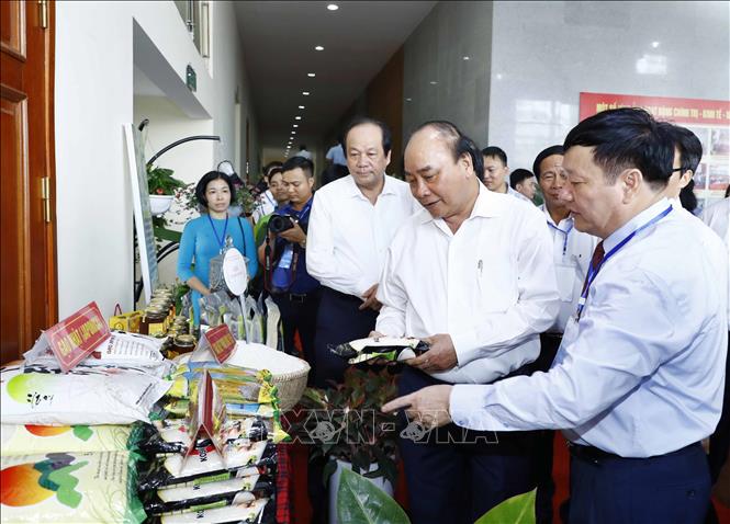 Trong ảnh: Thủ tướng Nguyễn Xuân Phúc và các đại biểu tham quan khu vực trưng bày sản phẩm đặc trưng của vùng đồng bằng Bắc Bộ. Ảnh: Thống Nhất- TTXVN