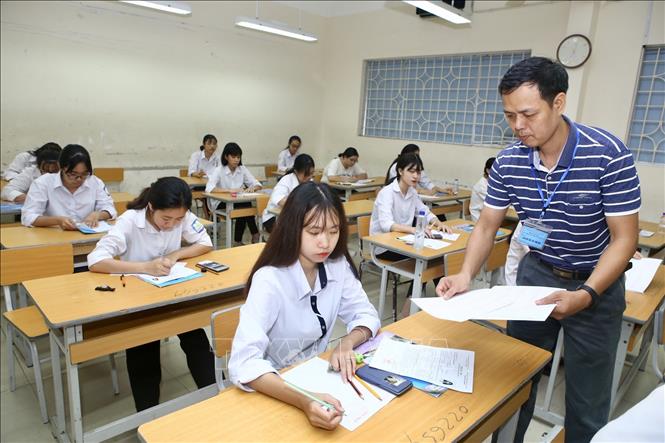 Trong ảnh: Giám thị phát Phiếu trả lời trắc nghiệm bài thi môn Địa lý tại Hội đồng thi trường THPT Nguyễn Gia Thiều (Hà Nội). Ảnh: Minh Quyết - TTXVN