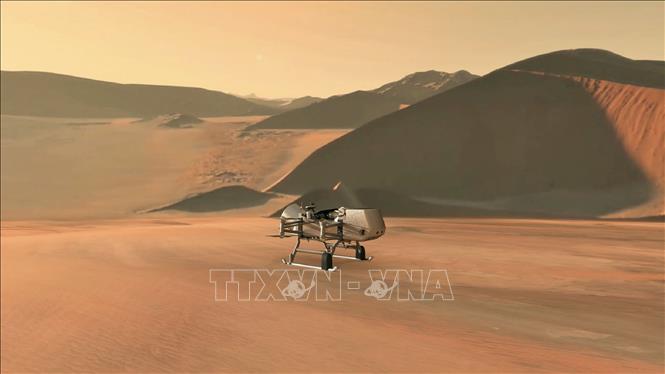 Trong ảnh: Hình ảnh mô phỏng do NASA công bố ngày 27/6/2019 cho thấy tàu thăm dò Dragonfly tiếp cận vệ tinh Titan của sao Thổ. Ảnh: AFP/ TTXVN