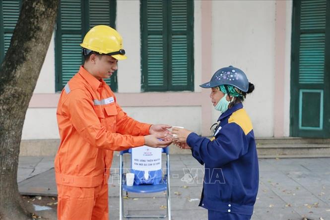 Trong ảnh: Người đi đường được uống nước miễn phí tại Điện lực quận Long Biên. Ảnh: Tiến Hiệp-TTXVN