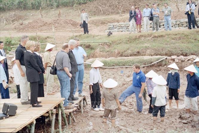 Với truyền thống và chính sách nhân đạo, Việt Nam đã và đang hợp tác tốt với Hoa Kỳ trong việc giải quyết vấn đề quân nhân Hoa Kỳ mất tích trong chiến tranh (POW/MIA). Tính đến nay, đội tìm kiếm hỗn hợp của hai nước đã tìm thấy, hồi hương 727 bộ hài cốt quân nhân Hoa Kỳ. Trong ảnh: Trong chuyến thăm chính thức tới Việt Nam tháng 11/2000, Tổng thống Hoa Kỳ Bill Clinton đến thăm hiện trường khai quật chiếc máy bay Mỹ F105D bị bắn rơi năm 1967 ở thôn Đại Lợi, xã Tiền Châu, huyện Mê Linh, tỉnh Vĩnh Phúc. Ảnh: Trọng Nghiệp - TTXVN