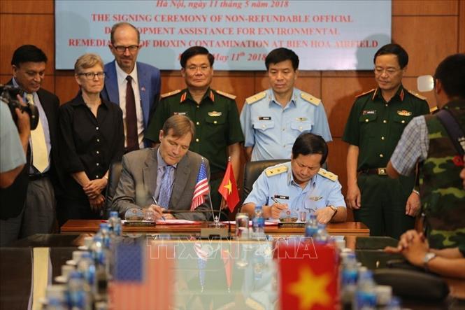 Phía Hoa Kỳ cũng đang từng bước hợp tác với Việt Nam trong việc giải quyết các vấn đề hậu quả chiến tranh ở Việt Nam. Trong ảnh: Trung tướng Lê Huy Vịnh, Tư lệnh Quân chủng Phòng không- Không quân và ông Michael Greene, Giám đốc Cơ quan Phát triển Quốc tế Hoa Kỳ (USAID) tại Việt Nam ký Thỏa thuận viện trợ không hoàn lại về xử lý dioxin khu vực Sân bay Biên Hòa (Đồng Nai), ngày 11/5/2018. Ảnh: Dương Giang – TTXVN