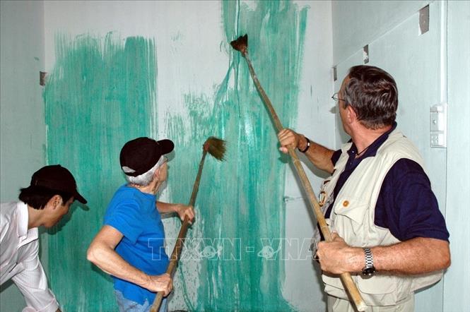 Trong ảnh: Cựu binh Mỹ quét vôi ngôi nhà mới của một nạn nhân bom mìn trong chiến tranh ở xã Hài Trường, huyện Hải Lăng, Quảng Trị, trong chuyến thăm và làm việc tại một số địa phương của Việt Nam của Đoàn đại biểu Quỹ tưởng niệm Cựu chiến binh Mỹ (VVMF) từ 19 - 26/8/2007. Ảnh: Tùng Lâm-TTXVN