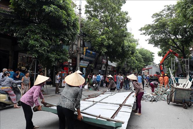 Trong ảnh: Tháo dỡ, vận chuyển các phần sập đổ của ngôi nhà. Ảnh: Huy Hùng - TTXVN