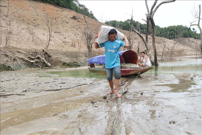 Trong ảnh: Lòng hồ cạn nước khiến việc đi lại, vận chuyển của người dân khó khăn. Ảnh: Nguyễn Oanh - TTXVN