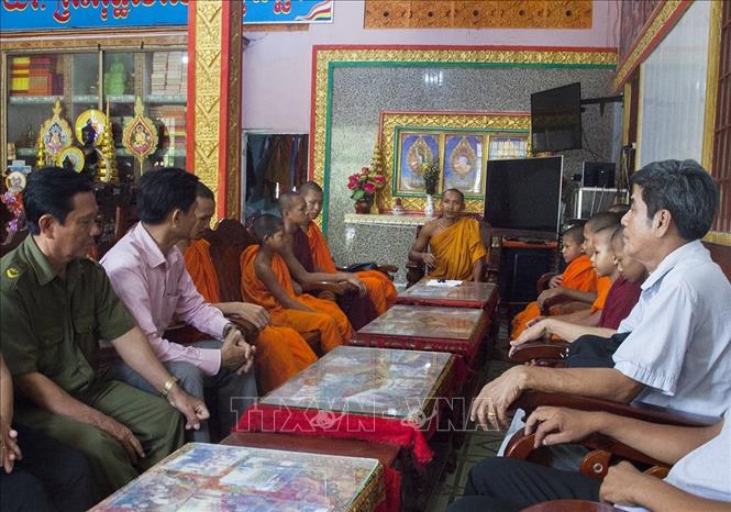 Trong ảnh: Đại Đức Danh Pu (giữa) làm việc cùng chính quyền xã Thạnh Lộc, huyện Châu Thành. Ảnh: Hồng Đạt - TTXVN
