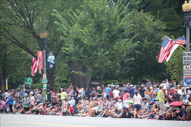 Người dân Mỹ chờ đoàn diễu hành đi qua tại đại lộ Constitution Avenue tại Thủ đô Washington DC. Ảnh: Đặng Huyền - TTXVN tại Mỹ