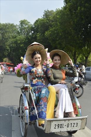 Với cộng đồng quốc tế, Thủ đô Hà Nội là hình ảnh về một thành phố luôn phát triển năng động nhưng vẫn giữ những nét truyền thống. Trong ảnh: Những cô gái Hà Nội dạo phố trên những chiếc xe xích lô, trong trang phục áo dài truyền thống duyên dáng tạo nên hình ảnh rất đỗi thân quen, đặc trưng của Thủ đô Ngàn năm văn hiến. Ảnh: Thanh Hà - TTXVN