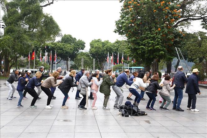Hà Nội là thành phố bình yên, có sức hấp dẫn lớn đối với du khách, các nhà đầu tư và khách quốc tế không chỉ bởi cảnh đẹp và bề dày văn hóa truyền thống, mà còn ở sự an toàn tuyệt đối, sự thân thiện, hiếu khách của người dân Thủ đô. Trong ảnh: Đoàn khách du lịch quốc tế cùng tập thể dục với người dân Thủ đô tại khu vực vườn hoa Lý Thái Tổ bên hồ Hoàn Kiếm. Ảnh: Minh Quyết – TTXVN