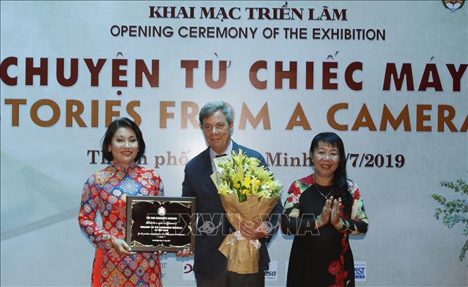 Trong ảnh: Ban tổ chức tặng hoa, quà cho Ngài Juan Carlos Valle Raleigh- Đại sứ Argentina tại Việt Nam tại triển lãm chuyên đề “Câu chuyện từ chiếc máy ảnh”. Ảnh: Hoàng Hải-TTXVN