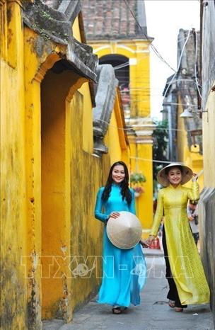 Photo: Vietnamese girls in traditional dress in the ancient quarter. VNA Photo: Minh Đức