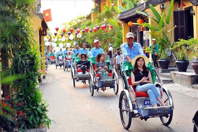 Photo: Tourists on a tour of Hội An town. VNA Photo: Minh Đức