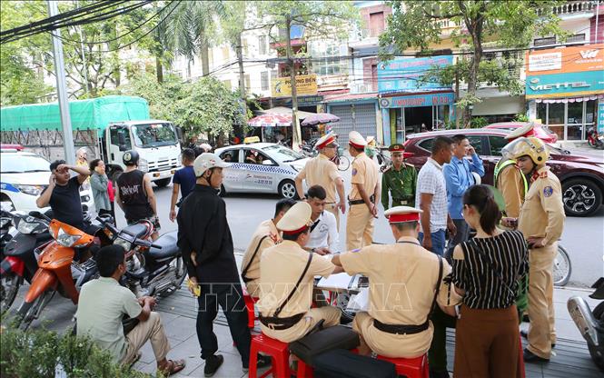 Trong ảnh: Cảnh sát giao thông tỉnh Bắc Ninh lập biên bản người điều khiển xe mô tô trên đường Ngô Gia Tự, phường Suối Hoa, thành phố Bắc Ninh. Ảnh: Doãn Tấn - TTXVN