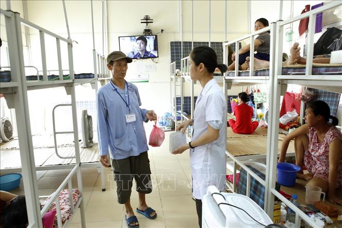 Trong ảnh: Cán bộ công tác xã hội bệnh viện K hướng dẫn người bệnh làm thủ tục đăng ký lưu trú miễn phí. Ảnh: Dương Ngọc - TTXVN