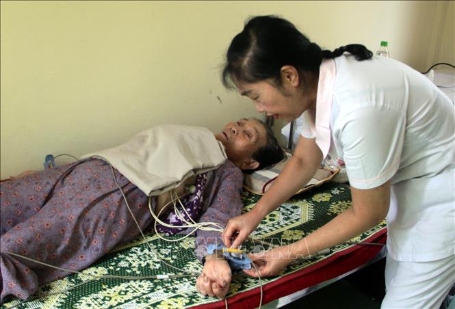 Trong ảnh: Các y, bác sỹ đo điện tâm đồ cho người bệnh. Ảnh: Trịnh Bang Nhiệm - TTXVN