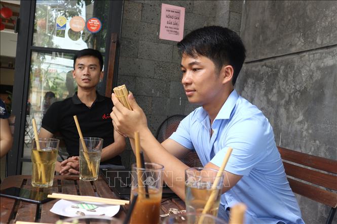 Trong arnh: Nguyễn Văn Mão với sản phẩm ống hút tre của mình tại quán cà phê. Ảnh: Bích Huệ - TTXVN