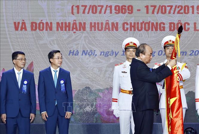 Trong ảnh: Thủ tướng Nguyễn Xuân Phúc gắn Huân chương Độc lập hạng Ba lên lá cờ truyền thống của Bệnh viện K Trung ương. Ảnh: Thống Nhất – TTXVN