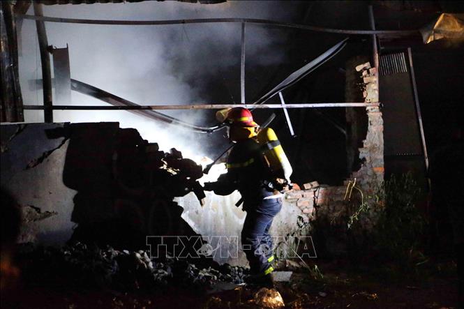 Trong ảnh: Cảnh sát phòng cháy, chữa cháy dùng búa phá bức tường nhà xưởng để chữa cháy. Ảnh: Doãn Tấn - TTXVN