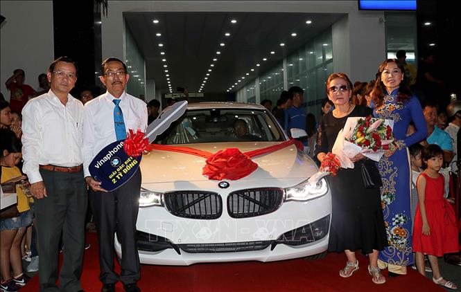 Trong ảnh: Đại diện Lãnh đạo VNPT Cà Mau trao thưởng xe ô tô BMW trị giá 2 tỷ đồng cho gia đình ông Văn Thanh Xuân, là khách hàng may mắn trúng thưởng Giải đặc biệt chương trình khuyến mãi “Xài Vina trúng siêu xe”. Ảnh: Kim Há/TTXVN