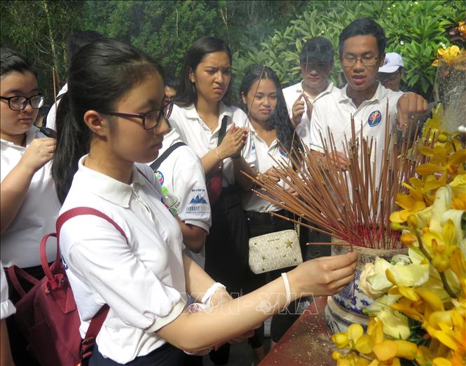 Photo: Young expats offer incense at patriot Huynh Thuc Khang's grave. VNA Photo: Phước Ngọc