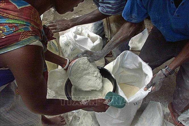 Trong ảnh: Người dân nhận bột mì cứu trợ của WFP tại Chiaquelane, Mozambique. Ảnh: AFP/TTXVN