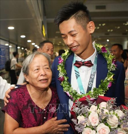 Trong ảnh: Các thí sinh trở về trong vòng tay chào đón của người thân, thầy cô và bạn bè. Ảnh: Thanh Tùng-TTXVN