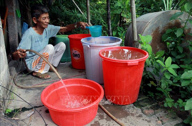 Trong ảnh: Ông Trần Văn Bàng 84 tuổi, thôn Kiều Mộc, xã Tự Tân, huyện Vũ Thư phải bơm nước từ sông lên để tắm giặt do thiếu nước sạch. Ảnh: Thế Duyệt - TTXVN 