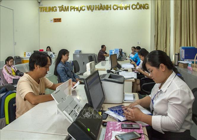 Trong ảnh: Nhân viên Trung tâm phục vụ hành chính công tỉnh Kiên Giang phục vụ người dân. Ảnh: Hồng Đạt - TTXVN

