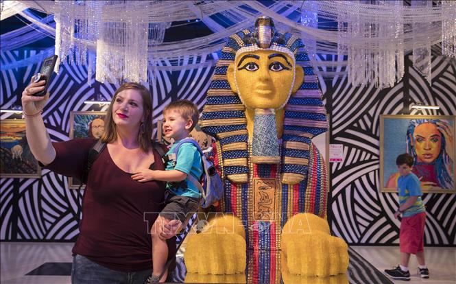 Trong ảnh: Khách tham quan chụp ảnh với các bức tượng làm từ các loại kẹo trưng bày tại triển lãm ở Houston,  Mỹ, ngày 4/8. Ảnh: THX/TTXVN