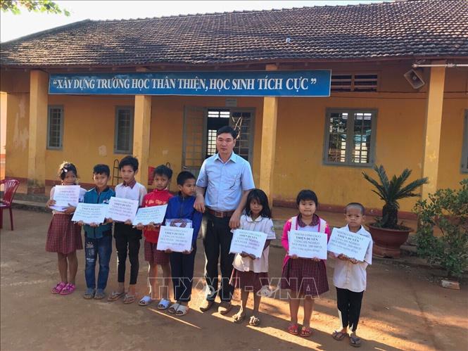 Trong ảnh: Nhóm cơm chay Thiện Duyên tặng quà cho học sinh nghèo tại xã biên giới Đắk Ơ. Ảnh: K GỬIH - TTXVN 