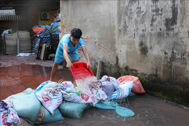 Trong ảnh: Người dân khu Đào Xá, phường Phong Khê, thành phố Bắc Ninh đắp bờ, ngăn nước tràn vào xưởng giấy. Ảnh: Thanh Thương – TTXVN
