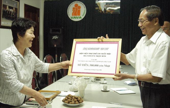Trong ảnh: Đại diện Hội Nạn nhân chất độc da cam/dioxin Việt Nam (bên phải) tiếp nhận số tiền 500.000 yên Nhật của ông Numanamin Yuichi ủng hộ các nạn nhân chất độc da cam/dioxin Việt Nam thông qua Hội viện trợ trẻ em chất độc da cam của Nhật (11/9/2008). Ảnh: Dương Ngọc - TTXVN