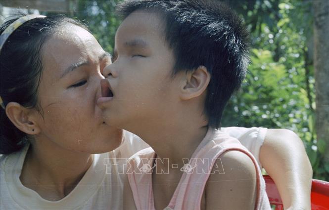 Trong ảnh: Chị Trương Thị Thi (thôn Nghĩa Phong, xã Cam Nghĩa, huyện Cam Lộ, tỉnh Quảng Trị) và con bị di chứng chất độc da cam/dioxin (2002). Ảnh: Ngô Mỹ - TTXVN