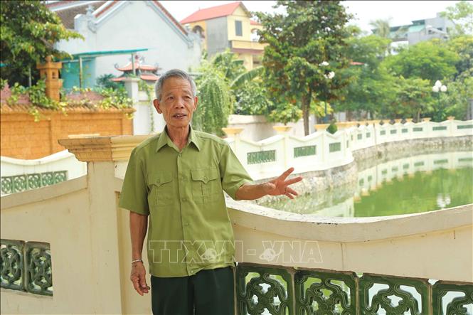 Trong ảnh: Ông Nguyễn Tứ Hùng nói về qua trình cùng gia đình vận động nhân dân trong xã đóng góp kinh phí và ngày công lao động xây dựng ao môi trường rộng hàng nghìn m2. Ảnh: Doãn Tấn, Văn Điệp – TTXVN