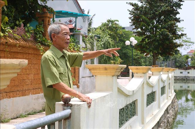 Trong ảnh: Ông Nguyễn Tứ Hùng nói về qua trình cùng gia đình vận động nhân dân trong xã đóng góp kinh phí và ngày công lao động xây dựng ao môi trường rộng hàng nghìn m2. Ảnh: Doãn Tấn, Văn Điệp – TTXVN