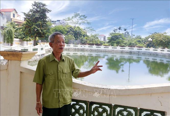 Trong ảnh: Ông Nguyễn Tứ Hùng nói về qua trình cùng gia đình vận động nhân dân trong xã đóng góp kinh phí và ngày công lao động xây dựng ao môi trường rộng hàng nghìn m2. Ảnh: Doãn Tấn, Văn Điệp – TTXVN