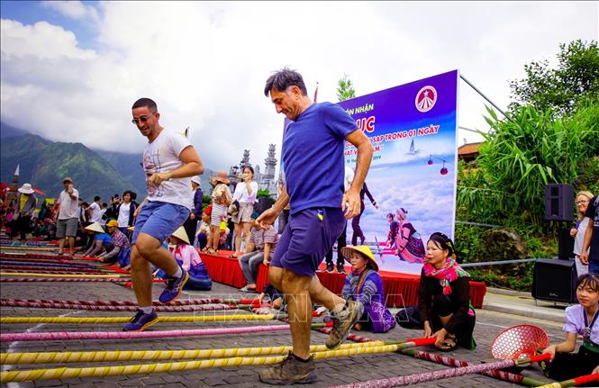Photo: Foreign tourists enjoy the dance. VNA Photo: Quốc Khánh