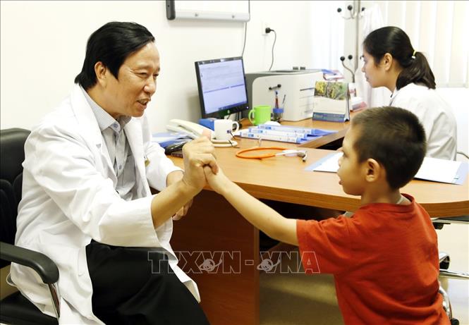 Trong ảnh: GS.TS Nguyễn Thanh Liêm khám lâm sáng, tư vấn ghép tế bào gốc điều trị cho trẻ bại não và tự kỷ. Ảnh: Dương Ngọc - TTXVN