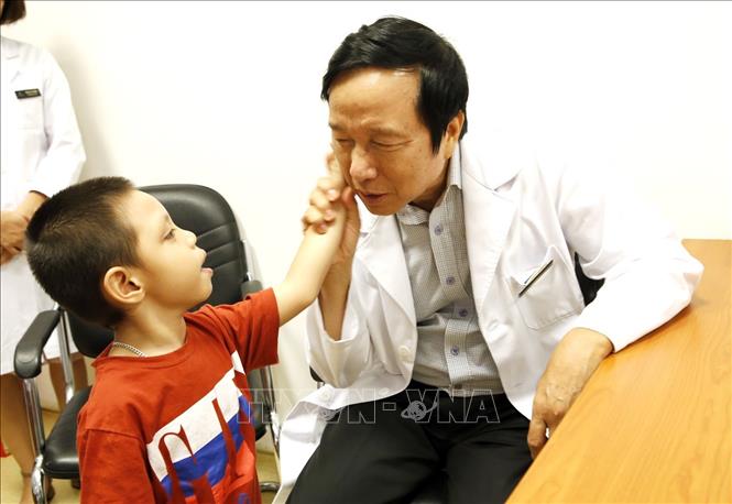Trong ảnh: GS.TS Nguyễn Thanh Liêm khám lâm sáng, tư vấn ghép tế bào gốc điều trị cho trẻ bại não và tự kỷ. Ảnh: Dương Ngọc - TTXVN