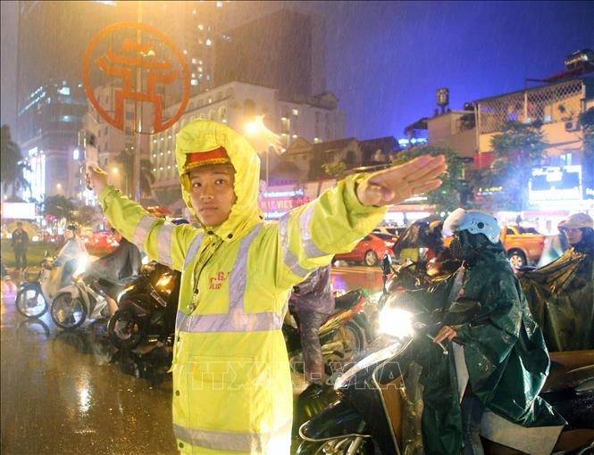Trong ảnh: Cảnh sát giao thông Đội 1 (Công an Hà Nội) hướng dẫn giao thông tại ngã tư Cửa Nam trong buổi tối mưa rét. Ảnh: Doãn Tấn – TTXVN