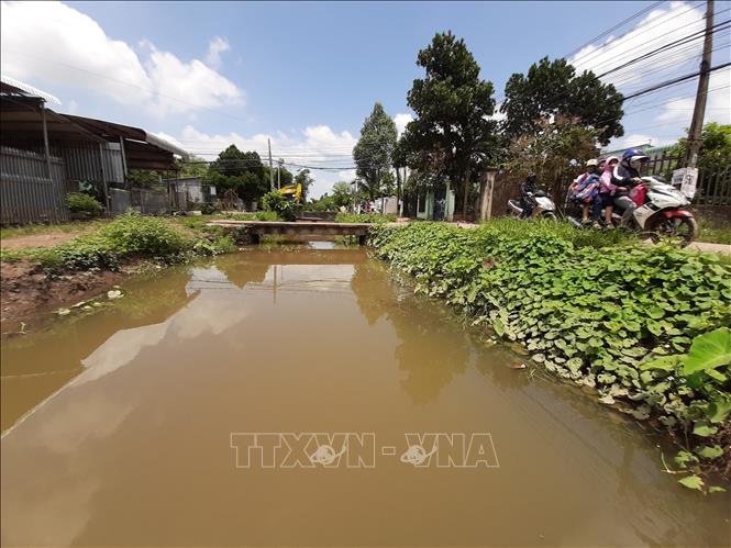 Học sinh tan trường về trên bờ suối Đồng Tiền trong khung cảnh đẹp giữa TP. Đồng Xoài.  Ảnh: Dương Chí Tưởng-TTXVN