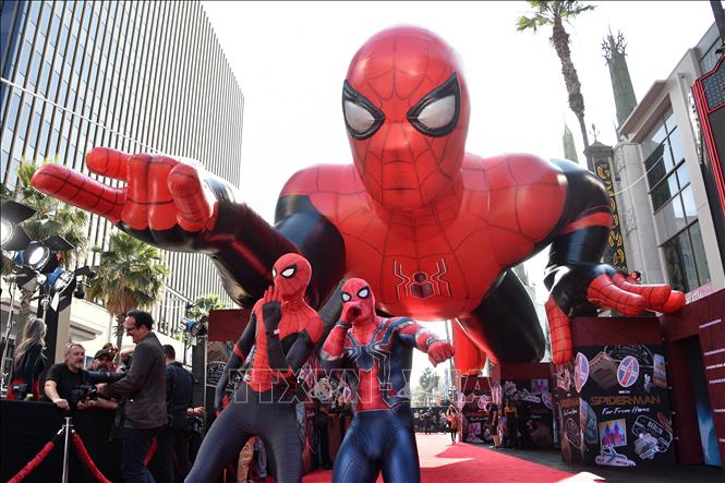 Trong ảnh: Trong ảnh: Những người hâm mộ trong trang phục Spider-Man chụp ảnh bên hình nộm khổng lồ  Spider-Man tại  Hollywood, Mỹ. Ảnh: AFP/TTXVN 