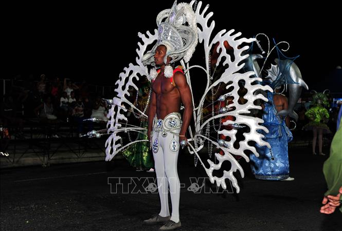 Trong ảnh: Một nghệ sĩ với “gùi lưng” mang khung trang trí đặc trưng cho hoạt động diễu hành Carnaval. Ảnh: Lê Hà - Pv TTXVN tại Cuba      