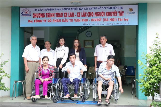 Trong ảnh: Trao xe lăn cho ngườn tàn tật có hoàn cảnh khó khăn. Ảnh: Huỳnh Phúc Hậu - TTXVN