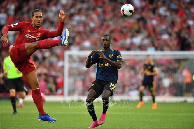 Trong ảnh: Pha đi bóng bổng của trung vệ Virgil Van Dijk (trái) trong trận đấu giữa CLB Liverpool và CLB Arsenal tại Giải Ngoại hạng Anh diễn ra ở Liverpool, Anh ngày 24/8/2019. Ảnh: AFP/TTXVN