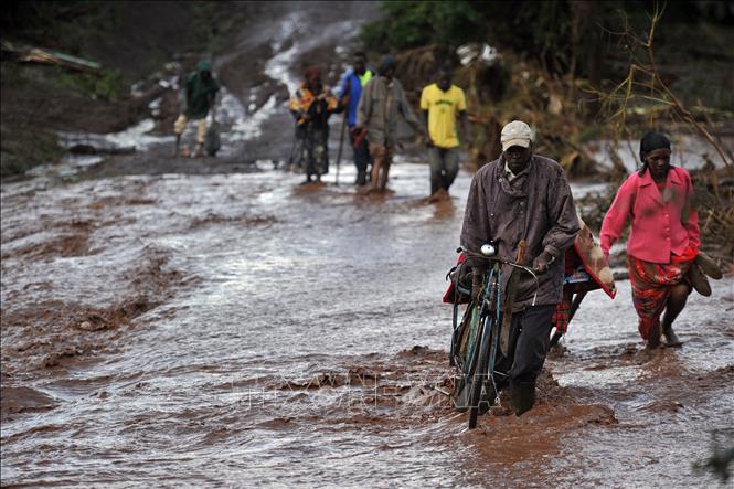 Trong ảnh (tư liệu): Người dân di chuyển qua khu vực ngập lụt tại Solai, Subukia, Nakuru, Kenya. Ảnh: AFP/ TTXVN