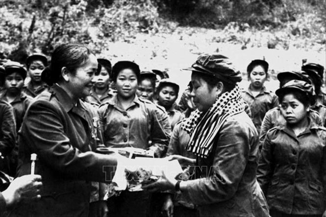 Trong ảnh: Chủ tịch Hội Liên hiệp Phụ nữ miền Nam Việt Nam Nguyễn Thị Định trao tặng phẩm cho đại đội nữ pháo binh trong chuyến thăm hữu nghị vùng giải phóng Lào (25 - 29/4/1974). Ảnh: Tư liệu TTXVN