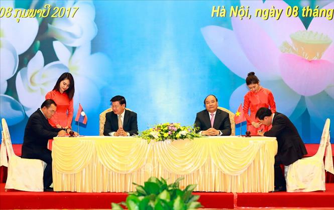 Trong ảnh: Thủ tướng Nguyễn Xuân Phúc và Thủ tướng Lào Thongloun Sisoulith chứng kiến Lễ ký biên bản thỏa thuận thành lập Công ty Liên doanh đầu tư Dự án xây dựng đường dây tải điện 500KV Lào - Việt Nam, tại Kỳ họp lần thứ 39 Uỷ ban liên Chính phủ Việt Nam - Lào, ngày 8/2/2017. Ảnh: Thống Nhất - TTXVN