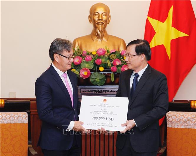 Trong ảnh: Ngày 26/7/2018, Thứ trưởng Bộ Ngoại giao Lê Hoài Trung gặp Đại sứ Lào tại Việt Nam Thongsavanh Phomvihane để gửi lời động viên, chia sẻ và trao số tiền của Chính phủ Việt Nam hỗ trợ Chính phủ, nhân dân Lào khắc phục hậu quả sự cố vỡ đập thủy điện Sepien Senamnoi ở tỉnh Attapeu. Ảnh: Lâm Khánh - TTXVN