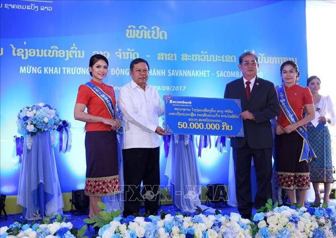 Trong ảnh: Đại diện Ngân hàng Sacombank Lào trao tượng trưng số tiền 50 triệu kip (tương đương khoảng 6.000 USD) cho đại diện tỉnh Savannakhet để đóng góp vào Quỹ ủng hộ thiên tai tỉnh Savannakhet. Ảnh: Phạm Kiên - TTXVN  

